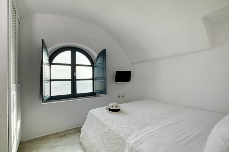 The amazing view from the bedroom of the luxury Junior Suite of Nostos Apartments in Oia Santorini